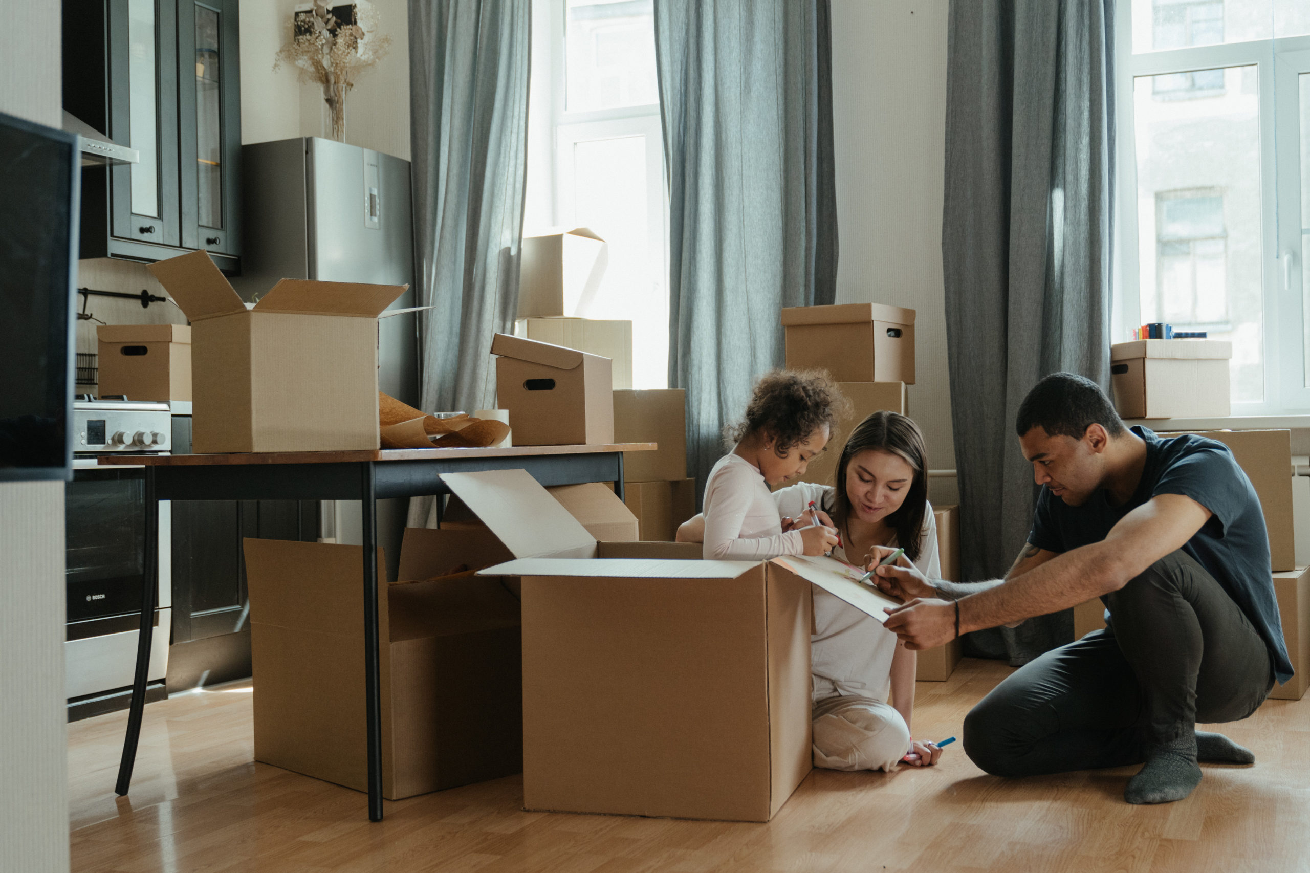 Couple with their daughter  unpacking after moving 