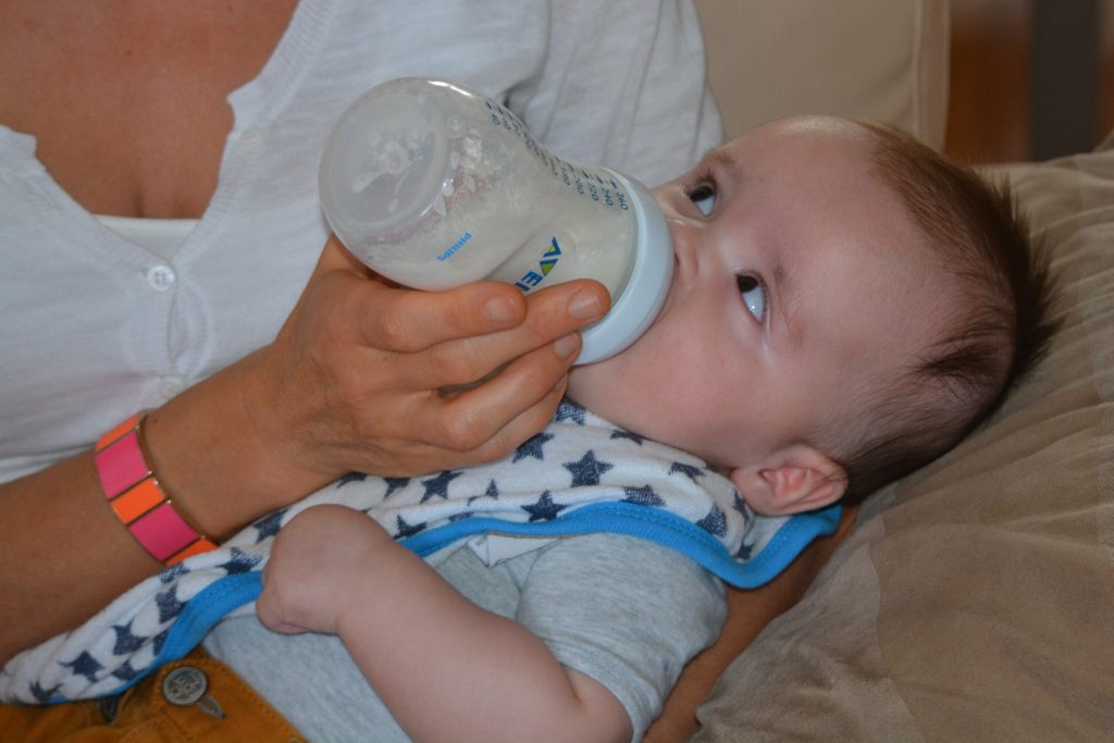 Woman feeding a baby with a milk bottle