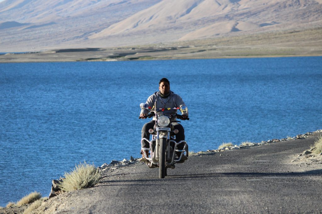 A man on a bike riding to Pangong Lake