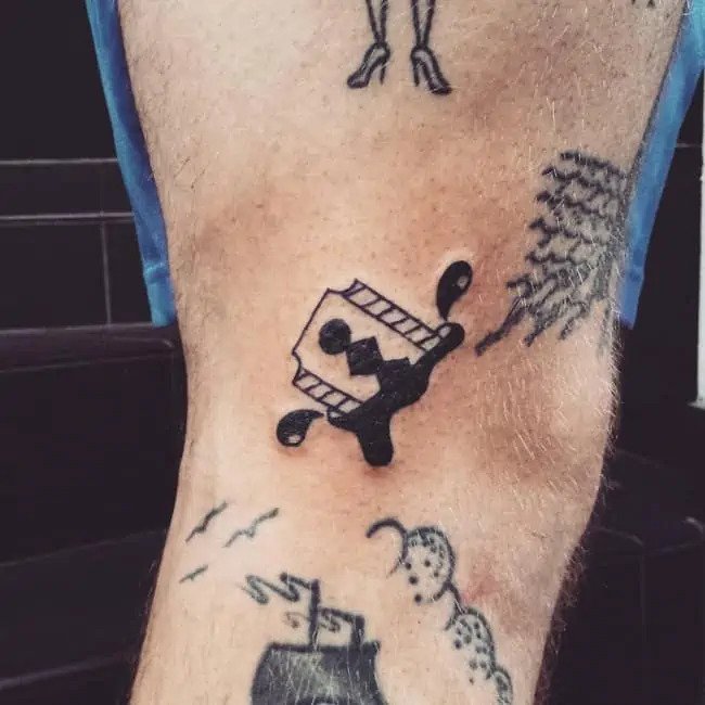 razor blade and blood gang tattoo on leg