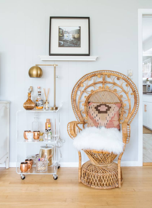 a peacock chair with fluffy white cushion