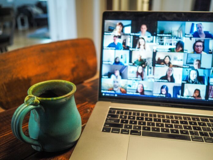 a laptop on table with a tea pot