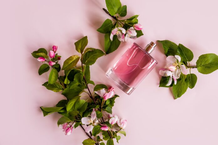 Floral Perfume in a bottle with flower and leaves around it