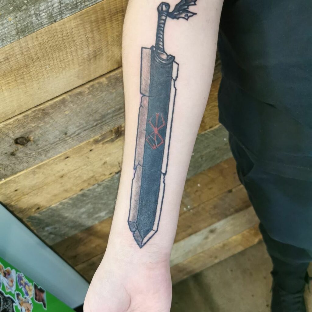 man flauting his Berserk sword tattoo on arm