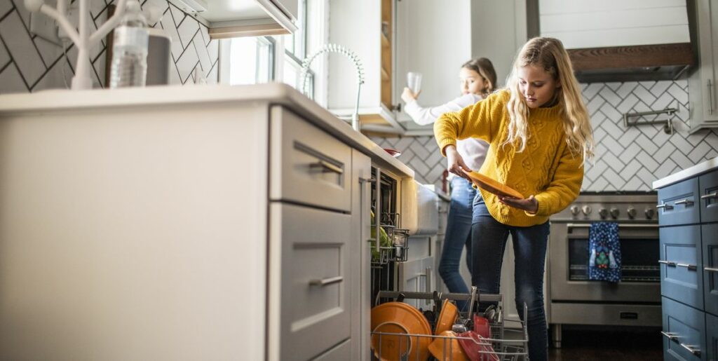 Two girls taking care of kitchen chores -one of the best jobs for 13 year olds